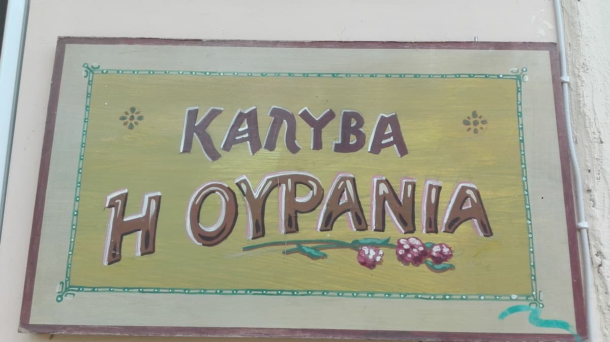 Hand-painted sign: Kalyva H Ourania \u2014 traditional cottage in Lysimachia, Greece